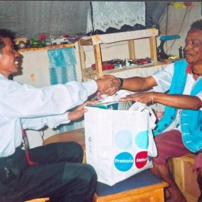 Dady Rabaraona (à droite) donnant un sac des produits pharmaceutiques au docteur du village